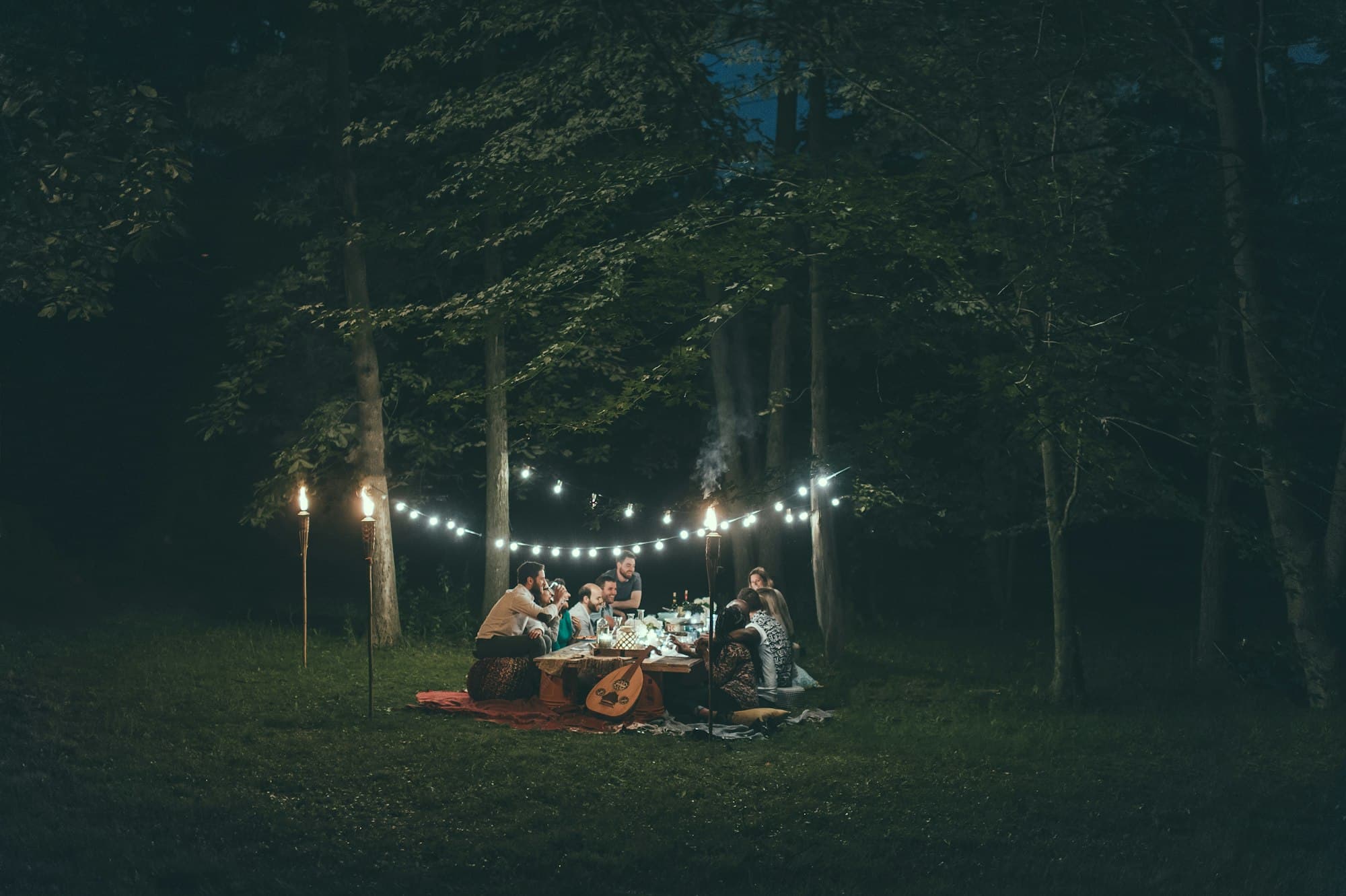 An evening gathering lit by string lights